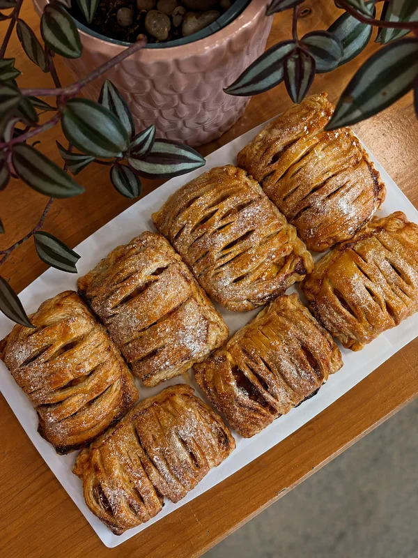 Golden pastries arranged beneath a trailing plant