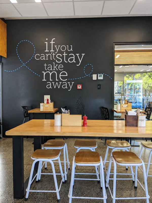 Therapy Coffee tables and stools beneath the ‘if you can’t stay take me away’ wall