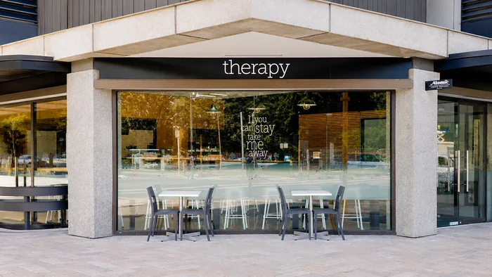 Therapy Coffee frontage with its therapy sign and outdoor tables
