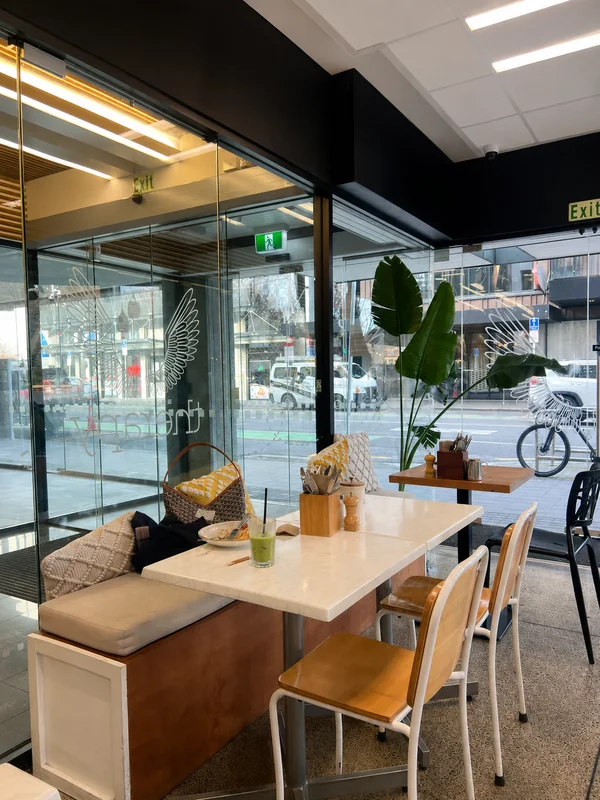 Window seats and wooden tables inside Therapy Coffee
